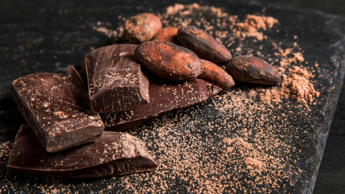 Étcsoki, kakaóbab és kakaópor közelről, ahol a keserű csoki jótékony hatása a természetes kakaós összetevőkhöz kapcsolódik